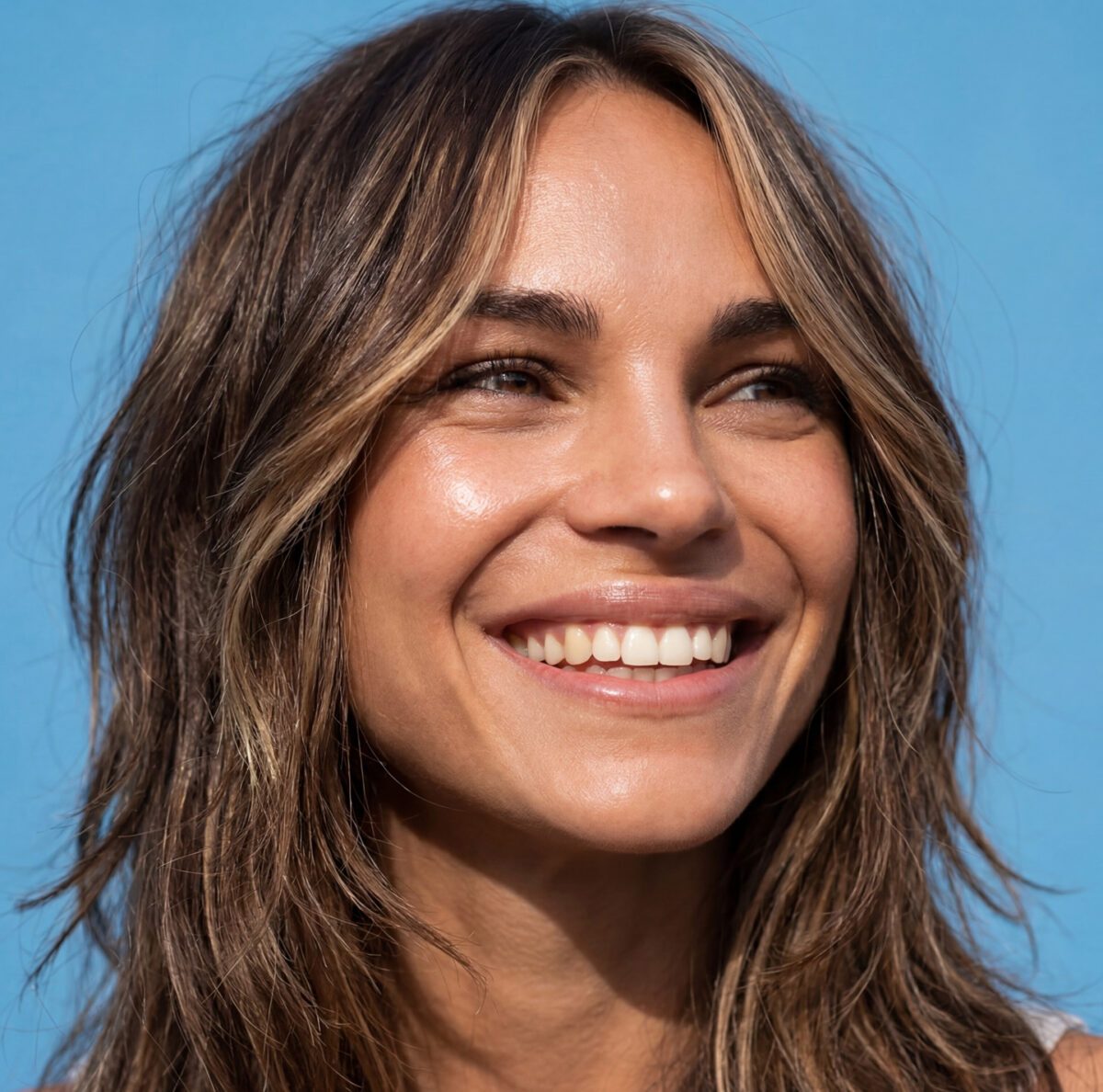 Woman with neck-length shag haircut smiling at camera.