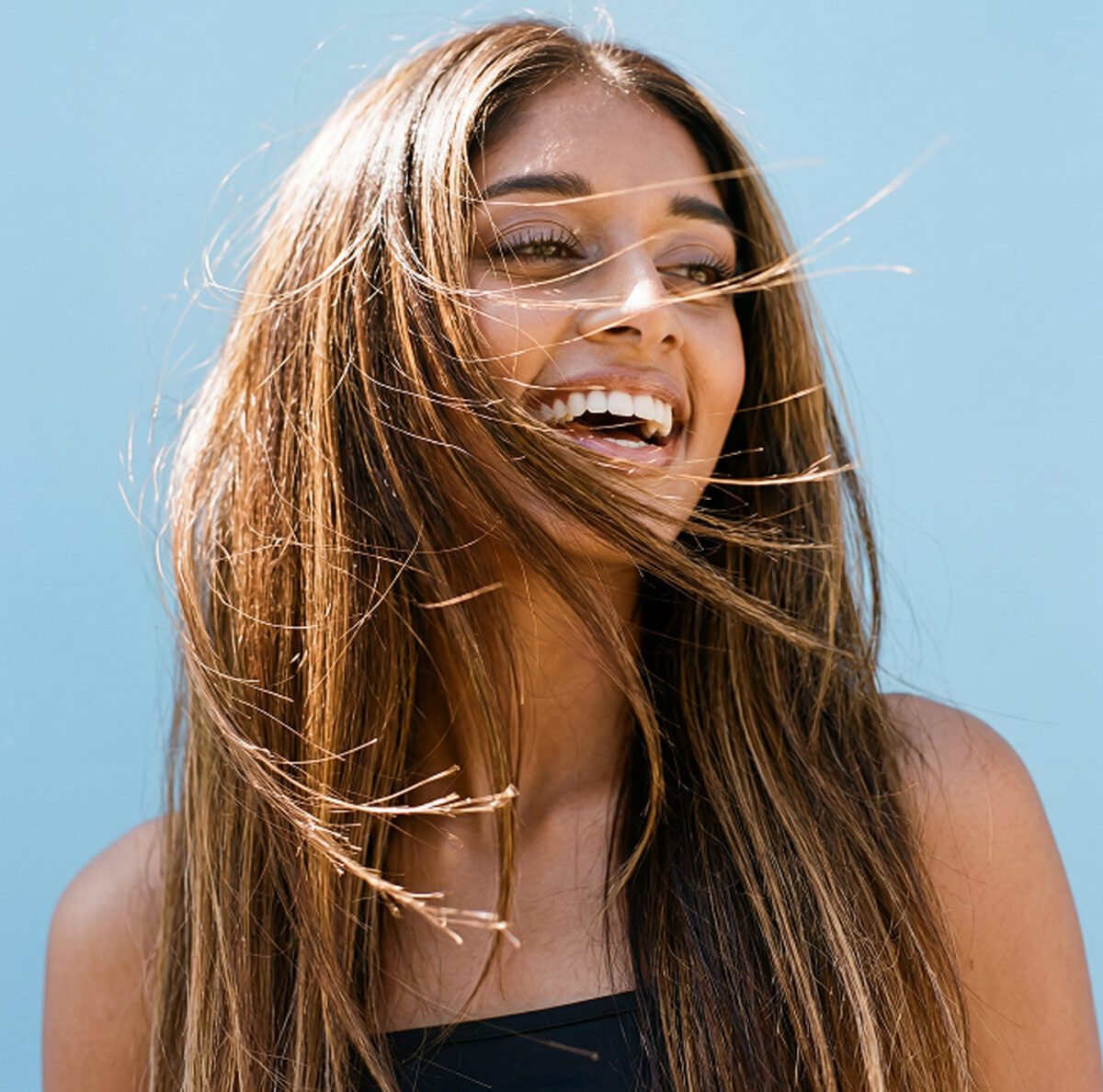 Woman with elbow-length hair showing Revive Restore results.