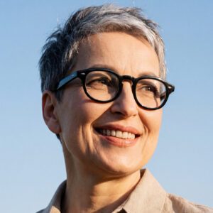 Senior-aged woman with black glasses and pixie cut