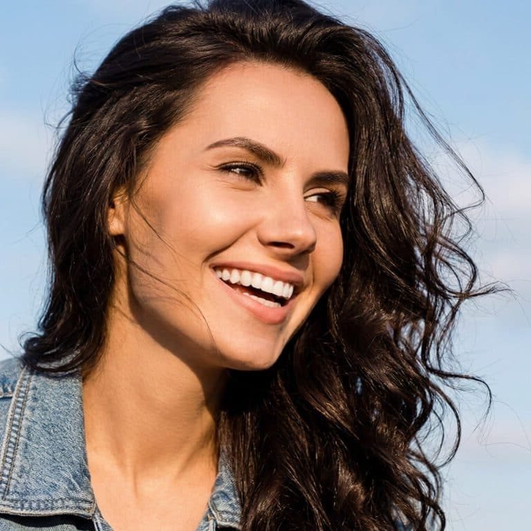 Woman with dark hair and smile representing waxing services.