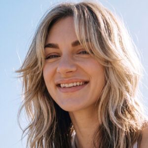 Smiling woman with shaggy wolf cut hairstyle and curtain bangs